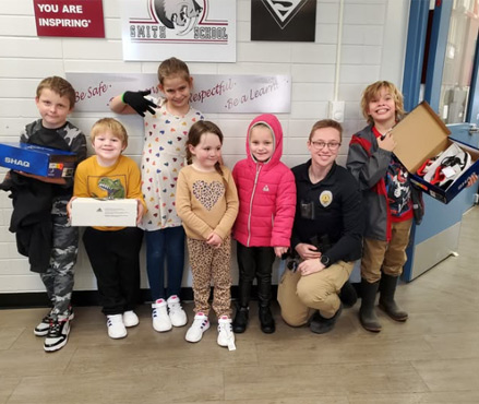 SRO Cornell presenting shoes to Smith students.